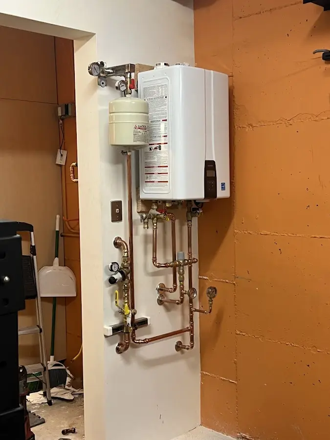 Plumbing technician inspecting water heater connections in Boise City